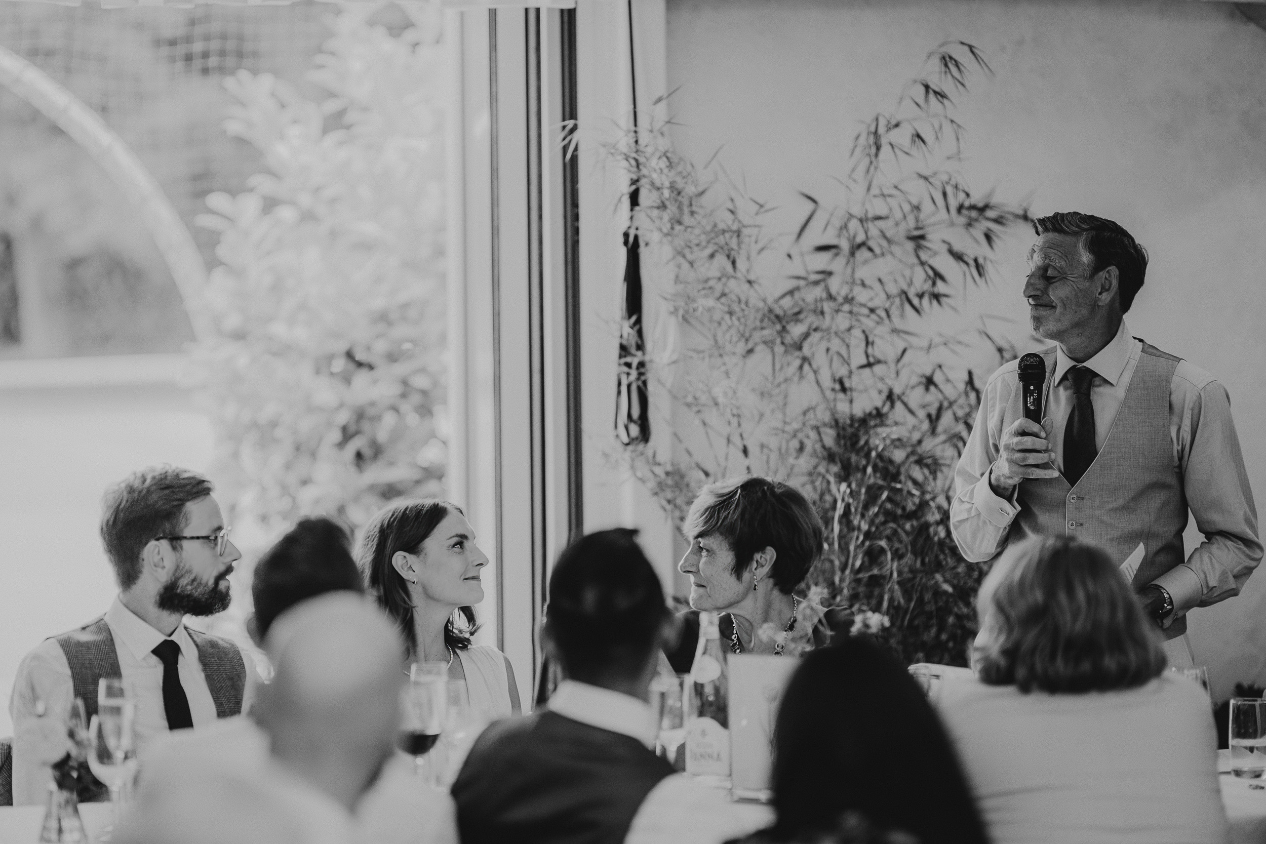 A black and white photo of a man giving a speech at a Surrey wedding.