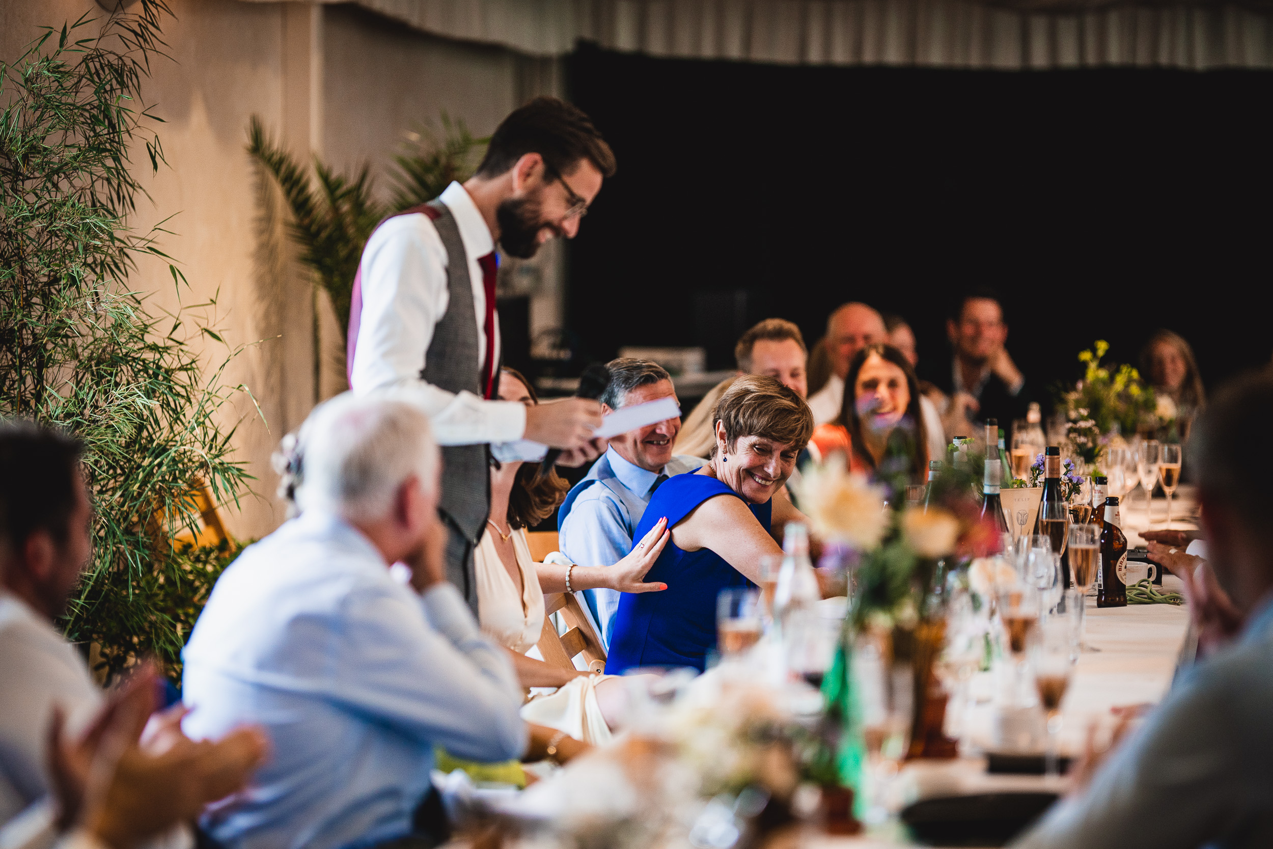 A man delivering a heartfelt speech at the Surrey Wedding reception.