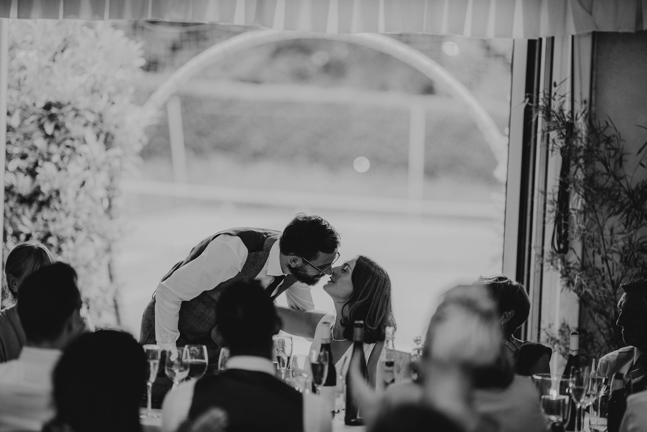 A bride and groom sharing a passionate kiss at their Surrey wedding reception held at Ridge Farm.