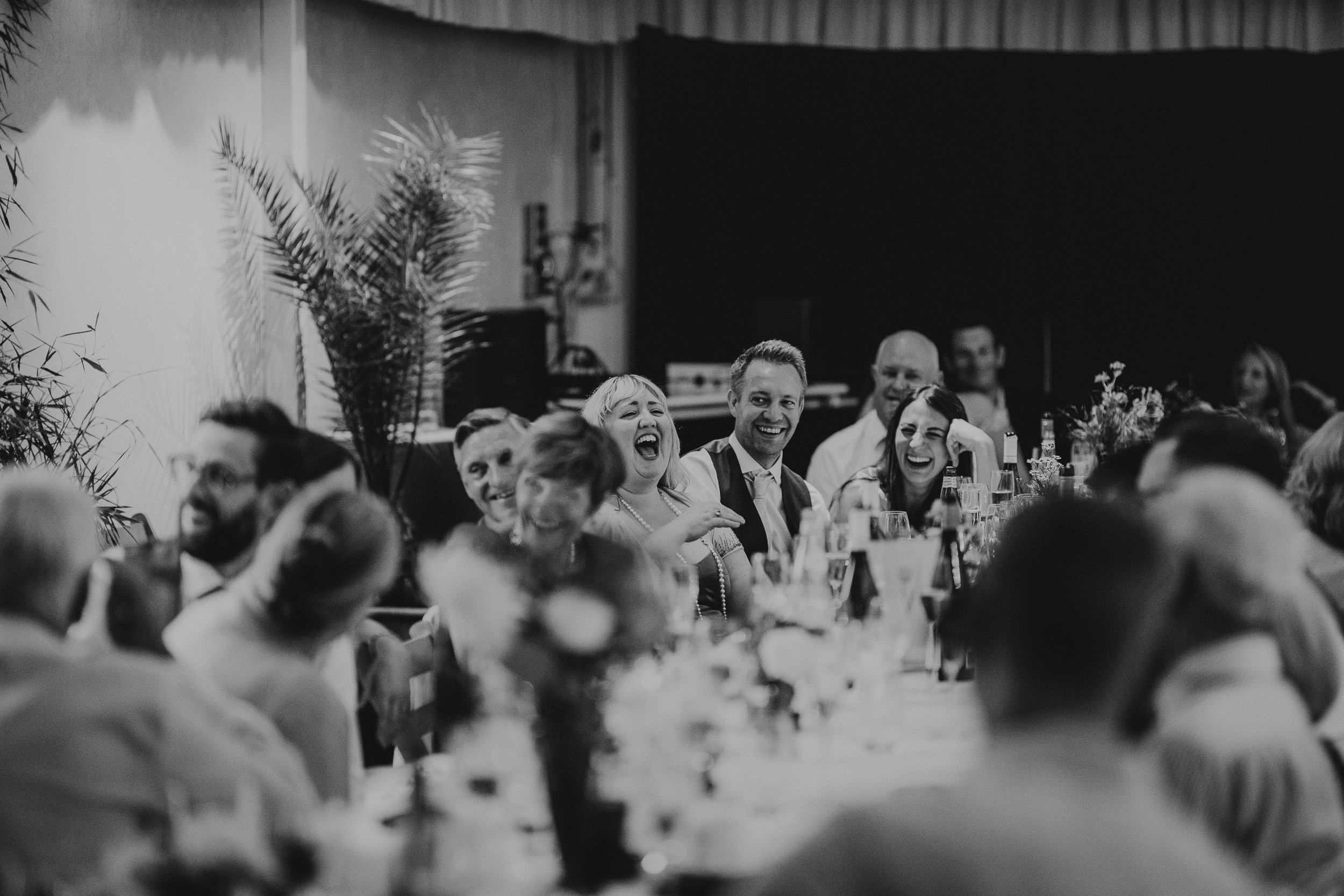 A black and white photo of people laughing at a Surrey wedding reception.