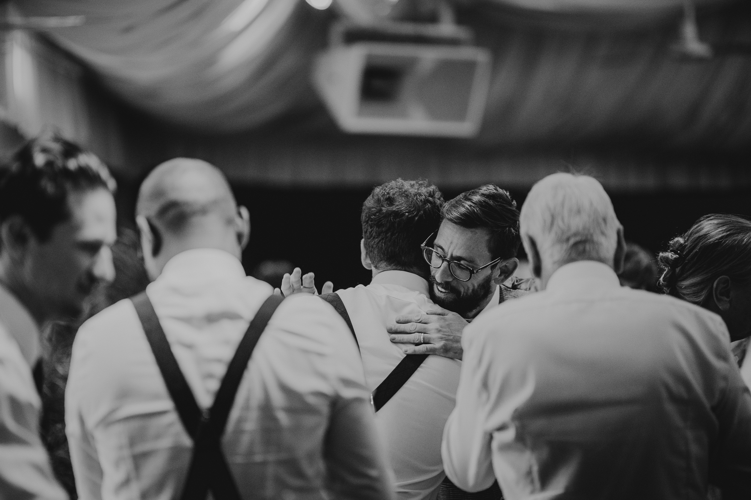 A group of men hugging each other at a Surrey wedding.