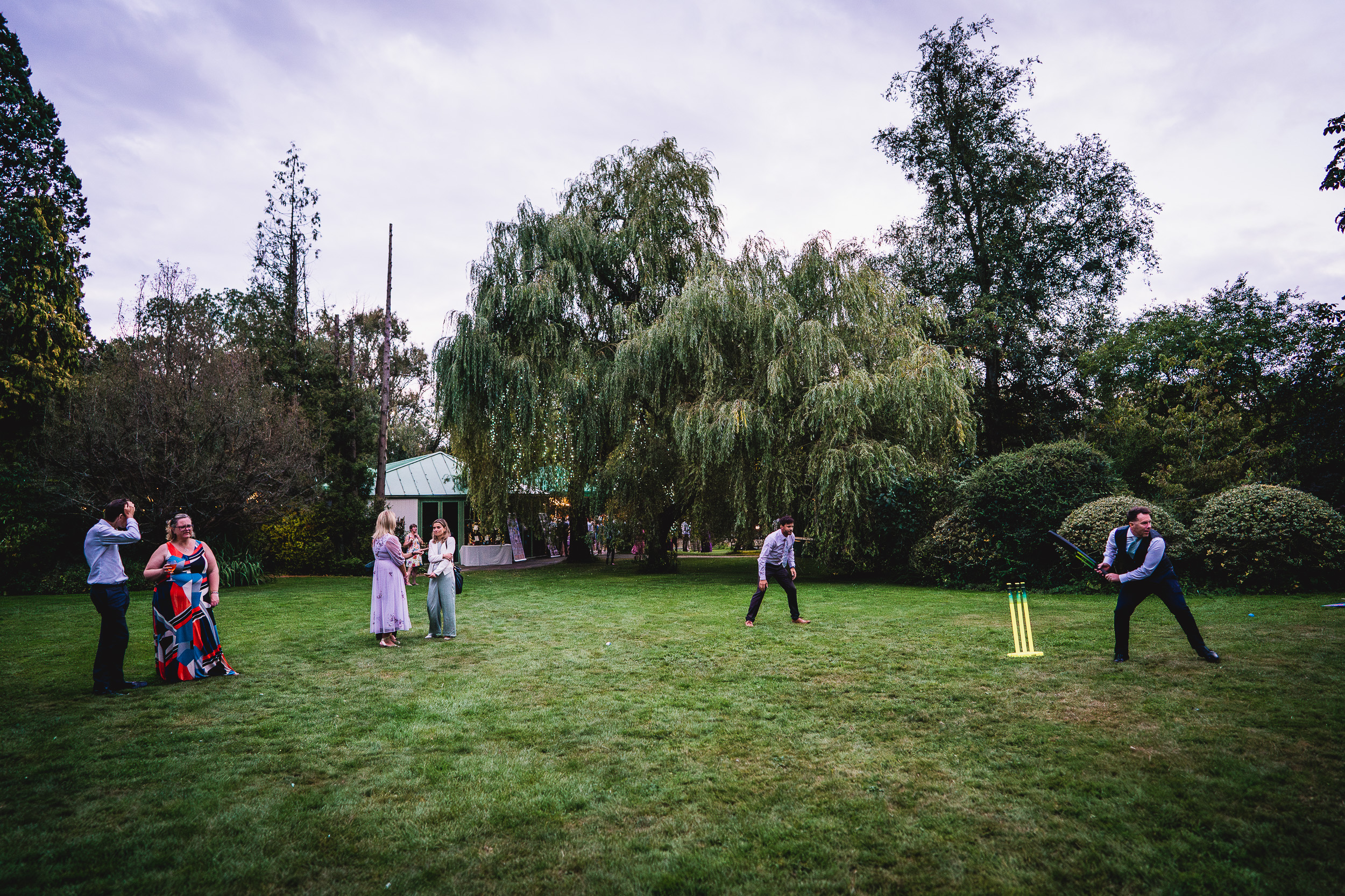 A group of people playing a game of cricket in Surrey Wedding.