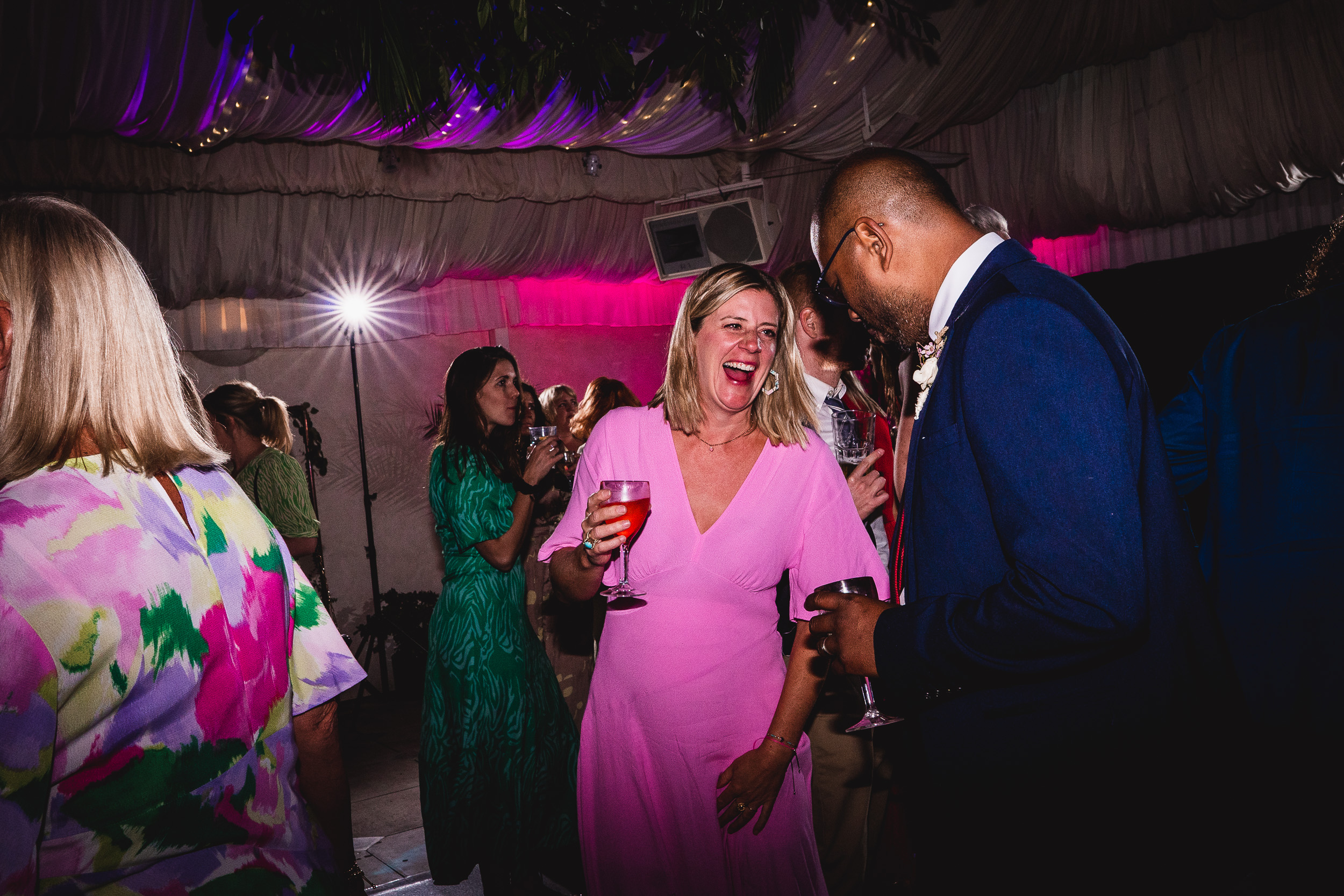 A group of people laughing at a Surrey Wedding party at Ridge Farm.